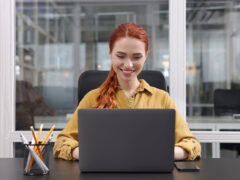 Junge Assistentin arbeitet an Laptop in Büro